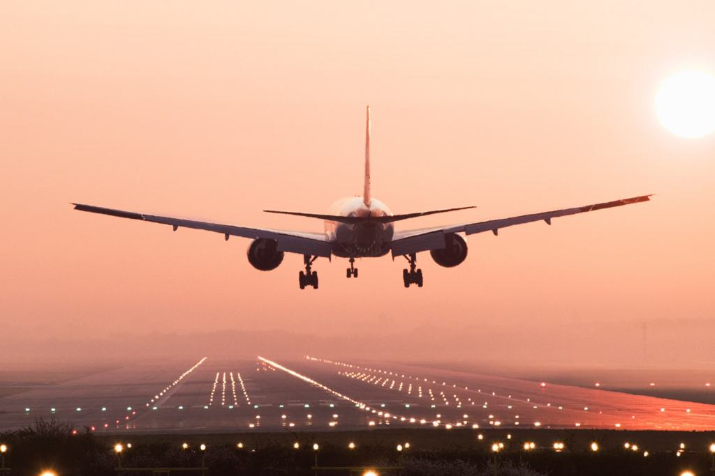 Airplane landing on a runway at sunset