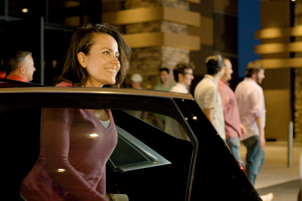 Woman exiting a black vehicle with a smile